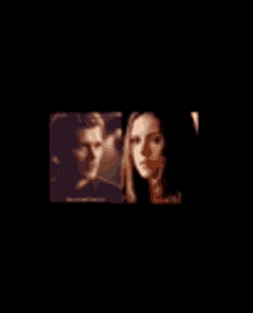a man and a woman are looking at each other in a dark room