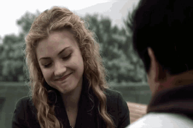 a man and a woman are looking at each other and smiling .