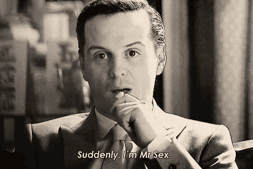 a man in a suit and tie is sitting in a chair and talking to someone .