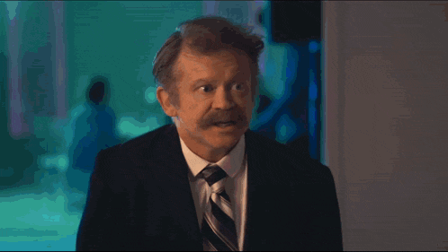 a man in a suit and tie says " you know " in white letters