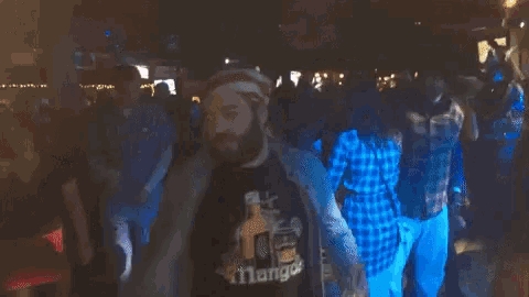 a man wearing a shirt that says ' atlanta ' on it is dancing in a crowd