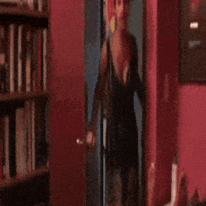 a woman in a black dress is standing in a doorway