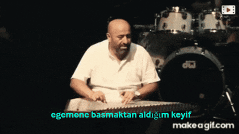 a man is playing a drum set in front of a make a gif.com sign