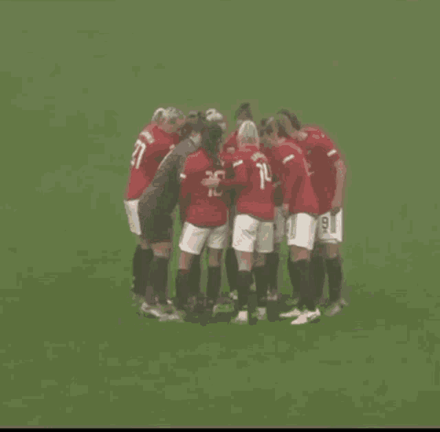 a group of soccer players are huddled together on the field and one of them has the number 10 on her jersey