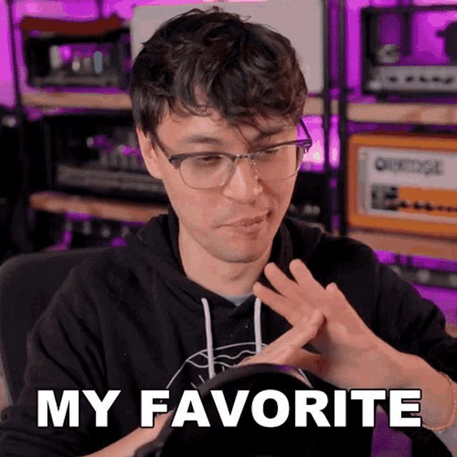 a man wearing glasses and a black hoodie says " my favorite " with his hands