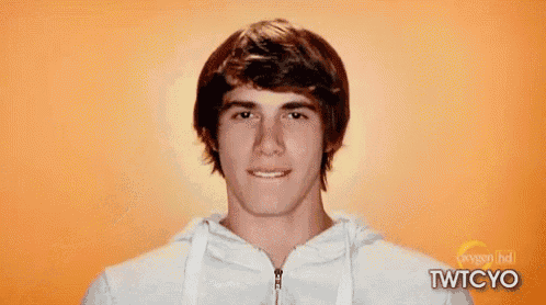 a young man is wearing a white hoodie and making a funny face .