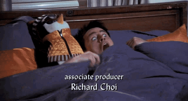 a man laying in bed with a stuffed animal and the name richard choi