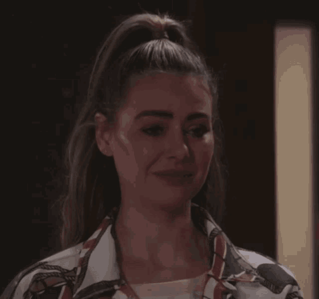 a woman with her hair in a ponytail is making a sad face