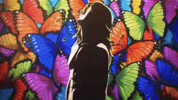 a woman standing in front of a wall of butterflies