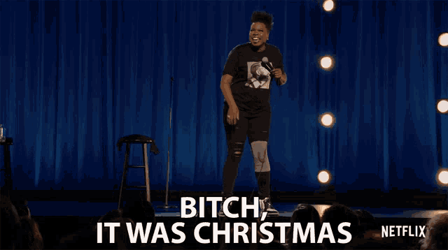 a woman stands on a stage with the words " bitch it was christmas " on the screen