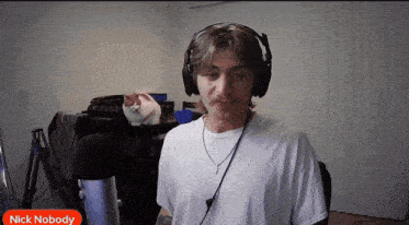 a man wearing headphones stands in front of a microphone with the name nick nobody on the bottom