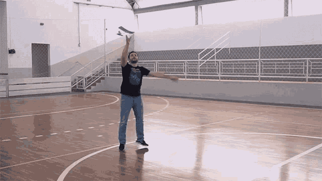 a man in a black shirt that says ' a ' on it stands on a basketball court