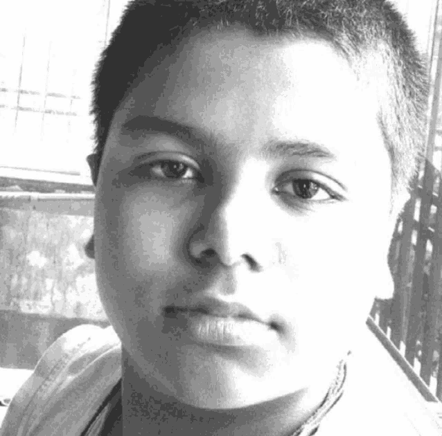 a black and white photo of a young boy with a very short haircut