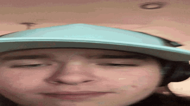 a man wearing headphones and a hat looks at the camera