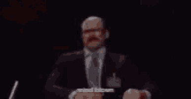 a man in a suit has blood coming out of his head and the words mind blown are visible