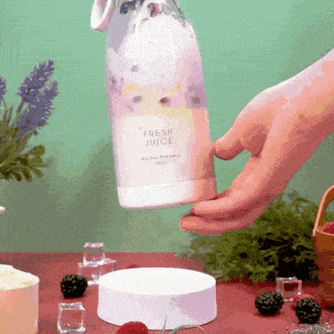 a bottle of fresh juice is being held by a hand