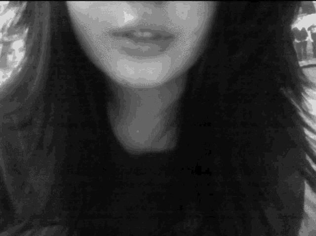 a black and white photo of a woman 's face with her mouth open