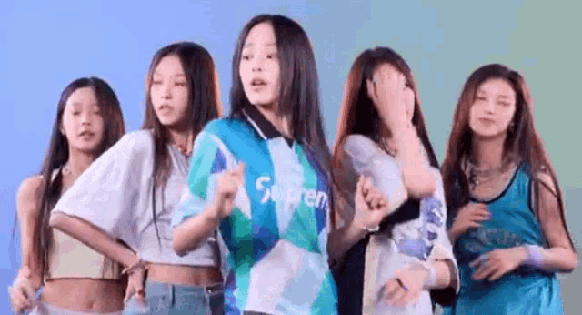 a group of young women are standing next to each other dancing .