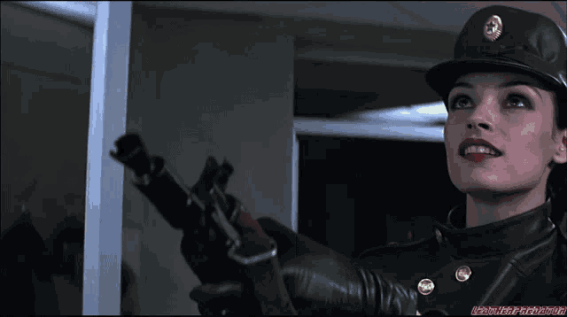 a woman in a military uniform holds a gun in her hand