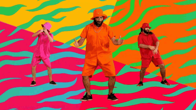 three men are dancing in front of a colorful background with flames