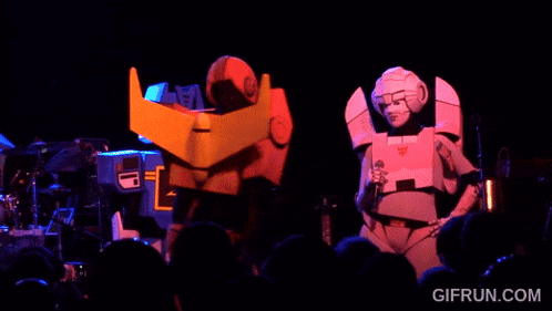 a group of people dressed as transformers on stage with gifrun.com at the bottom of the screen