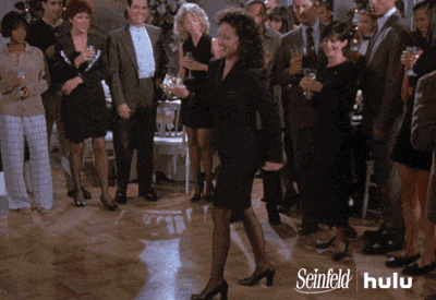 a woman in a black dress is dancing in front of a crowd of people with the words seinfeld hulu on the bottom right