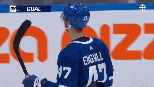 a hockey player with the number 47 on his jersey is holding a hockey stick