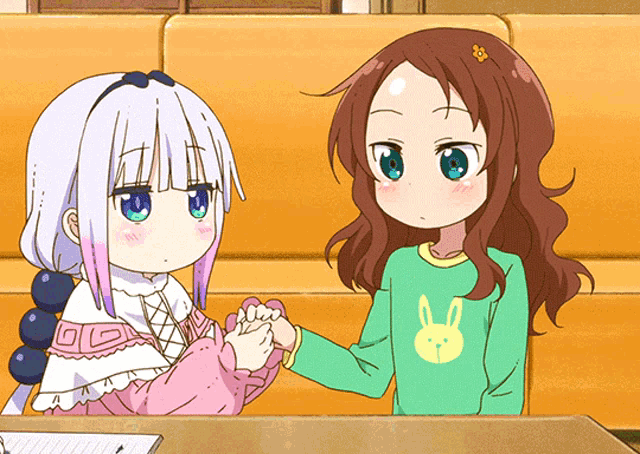 a girl in a green shirt with a bunny on it is holding the hand of another girl
