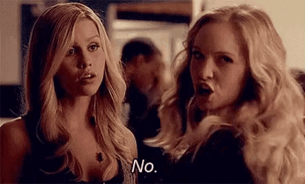 two blonde women are standing next to each other and one of them is saying `` no '' .