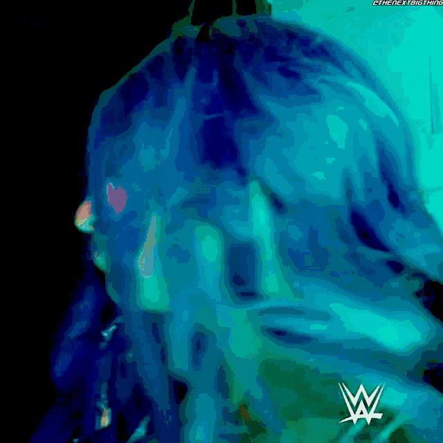 a close up of a person 's face with a wrestling logo in the corner