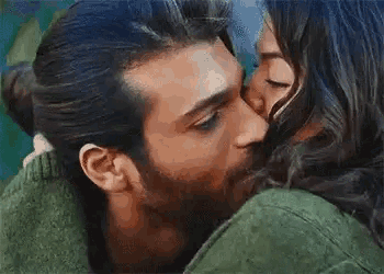 a man and a woman are kissing and hugging each other .