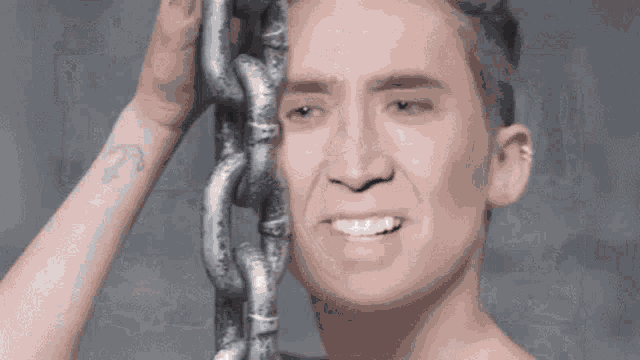 a shirtless man is holding a chain in his hand