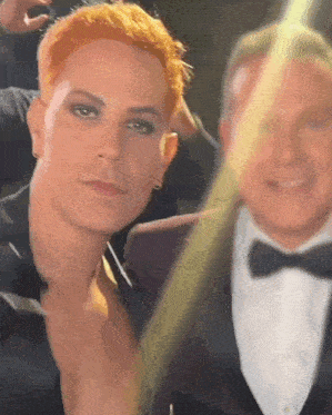 a man with red hair is posing for a picture with another man in a tuxedo