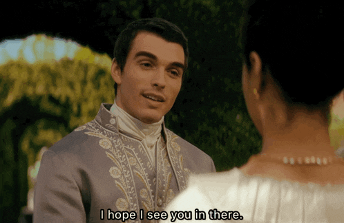 a man in a suit is talking to a woman in a white dress and says i hope i see you in there