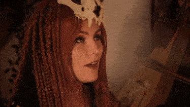 a woman with dreadlocks and a skull on her head is behind bars