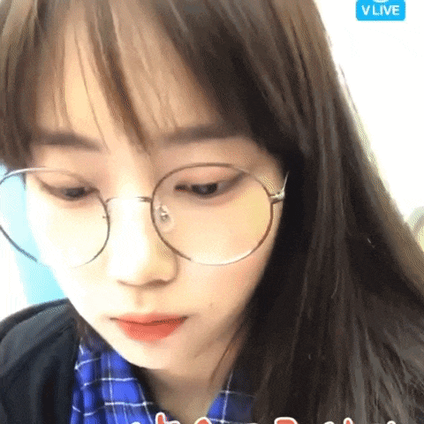 a close up of a girl wearing glasses and a blue plaid shirt