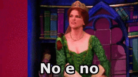 a woman in a green dress and tiara is standing in front of a bookshelf and says no e no .