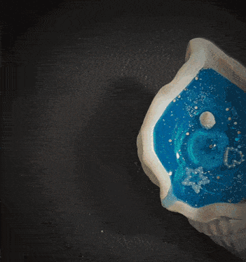 a person is lighting a candle in a sea shell