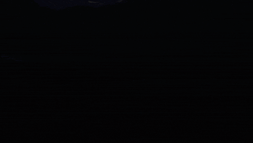 a dark room with a few lights shining in the distance