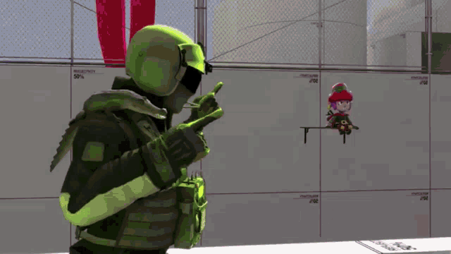 a man in a green helmet is pointing at a stuffed animal on a shelf