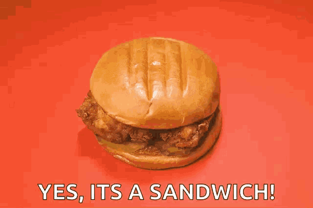 a chicken sandwich on a bun with the words yes it 's a sandwich written below it