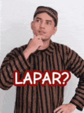 a man wearing a striped shirt and a hat with the word lapar written on it .