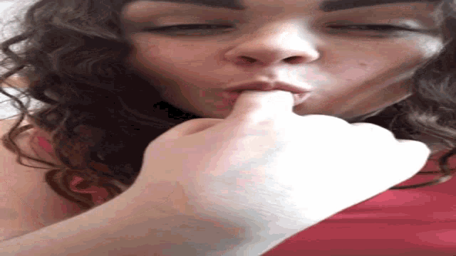 a close up of a woman 's face with her hand on her mouth