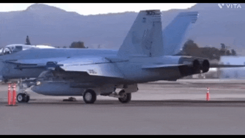 a fighter jet is sitting on the runway .