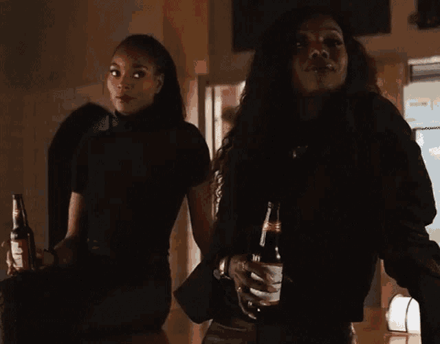 a woman holds a bottle of coca cola in front of another woman