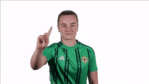 a woman wearing a green adidas shirt holds up a card