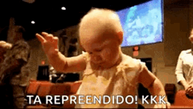 a baby is dancing in front of a screen that says ta representido kkk .