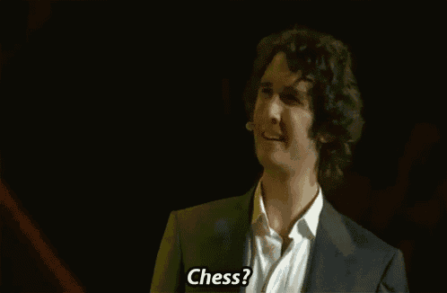 a man in a suit and white shirt is asking the question " chess "