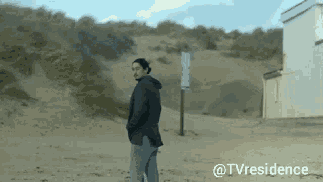 a man standing on a sandy beach with the words tvresidence below him