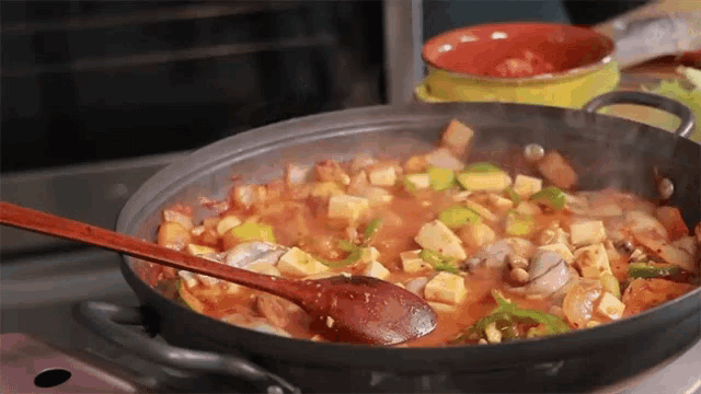 a wooden spoon is being used to stir a pot of food